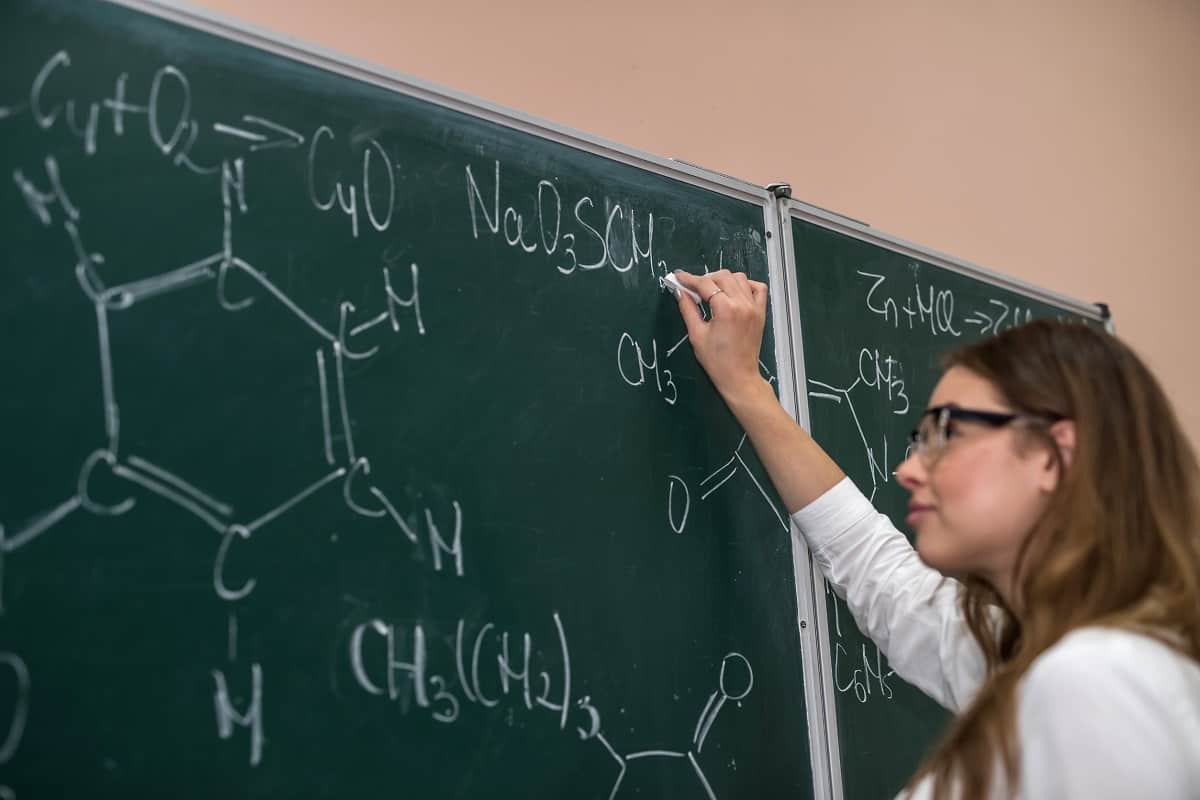 student at blackboard drawing organic chemistry diagrams